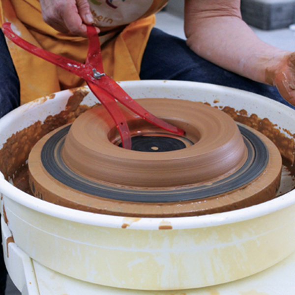 1 Open the centered clay to the wheel head. Taper the clay to the inside. Measure the diameter of the inside bowl.