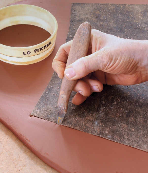 1 Place your tar-paper template onto the slab, then cut around it, holding your knife at a 45° angle. 