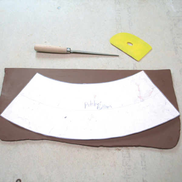 1 Roll a slab of clay wide enough to fit the template for the body of the pitcher.