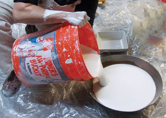 1 Pour the plaster slowly into the Vaseline-coated wok.