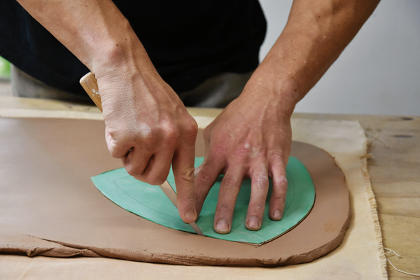 2 Using a thick-gauge paper template, cut out the basic plate shape from the slab.