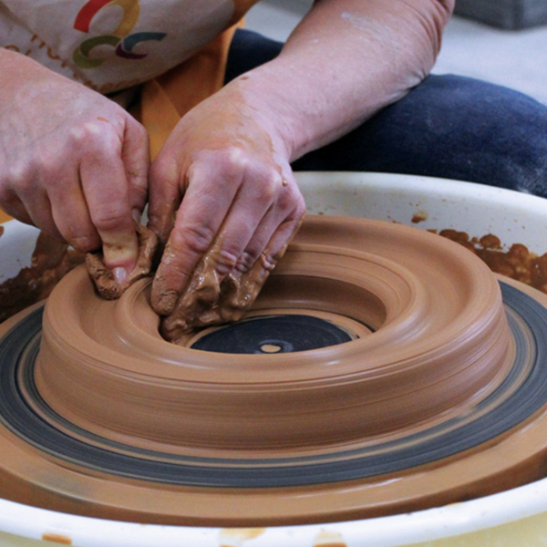 2 Split the clay by pressing straight down. Pull the inside ring up and in, leaving enough opening to pull again.