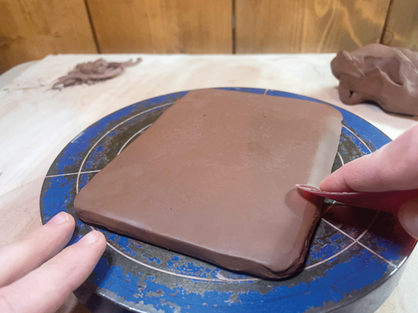 2 Using a soft rubber rib, lightly press down around the edges of the slab to create beveled edges. 