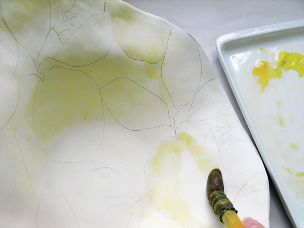 2 After applying a wash, fill in the light yellow of the lemon within the pencil lines, working from light to dark.
