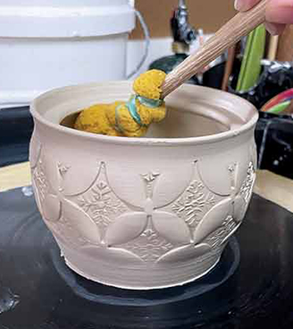 3 Add a layer of slip to the interior of the form after stamping, in preparation for expansion.