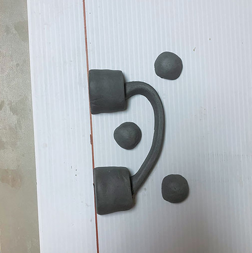 3 Place half of the handle, sprues, and registration balls onto corrugated plastic.