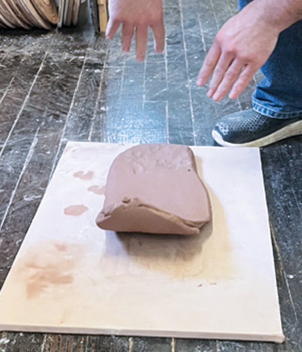 3 Stretch the clay slab by slamming it down and back in one arcing motion.
