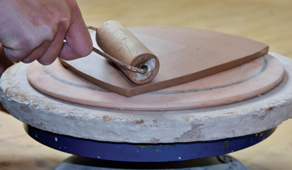 4 Gently compress the slab with a wooden roller to the curve of the mold.