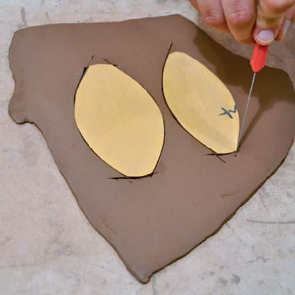 2 Create paper patterns of the handle shape that best fits the utensil, and cut it out of a clay slab.