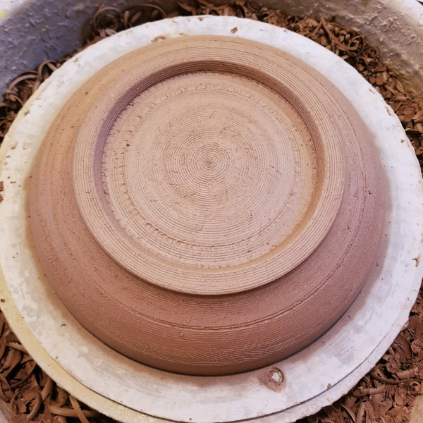 5 Trim the extra clay until even, while being mindful of the outside surface texture. I use a serrated rib to create texture when done.