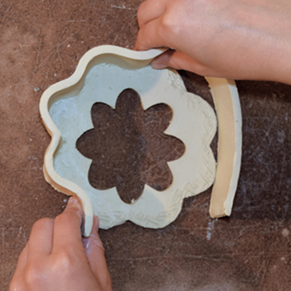 5 Cut a strip of clay to form the walls of the largest tier. Score and slip to attach.