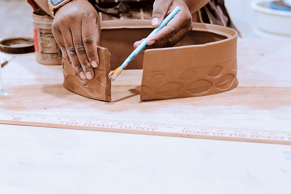 6 Lift the slab upright, then score, slip, and join both ends to create the body of the casserole dish. Use your hands to shape the pot into an oval. 