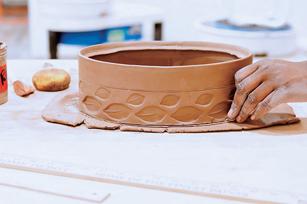 7 Trace the lower edge of the pot onto another slab of clay to create the bottom of the casserole dish. Cut out this shape and score along the perimeter. 