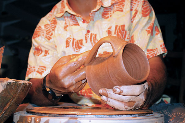 9 Drape the handle over the edge of the cylinder and snip off any excess clay.