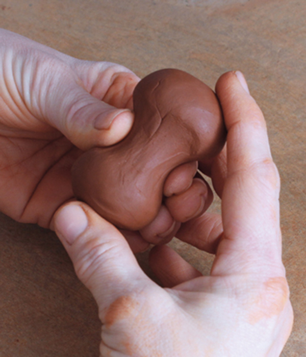 9 For the handle, pinch a ball of clay in the middle while rotating it to create a finger-bone-shaped form.