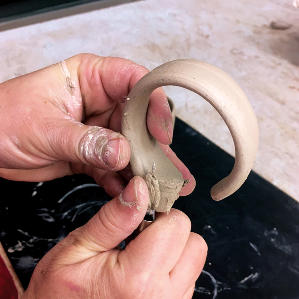 9 Cut the thick end of the larger handle piece to a rounded shape and smooth it.