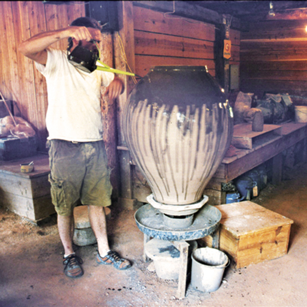 10 With the wheel turning over a basin to catch the runoff, pour slip over the pot.