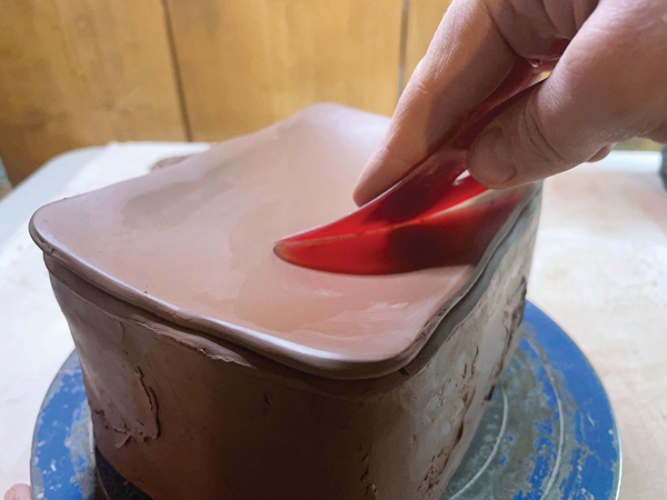 10 To create a curve in the lid, apply slight pressure with a rib from the edge toward the center.