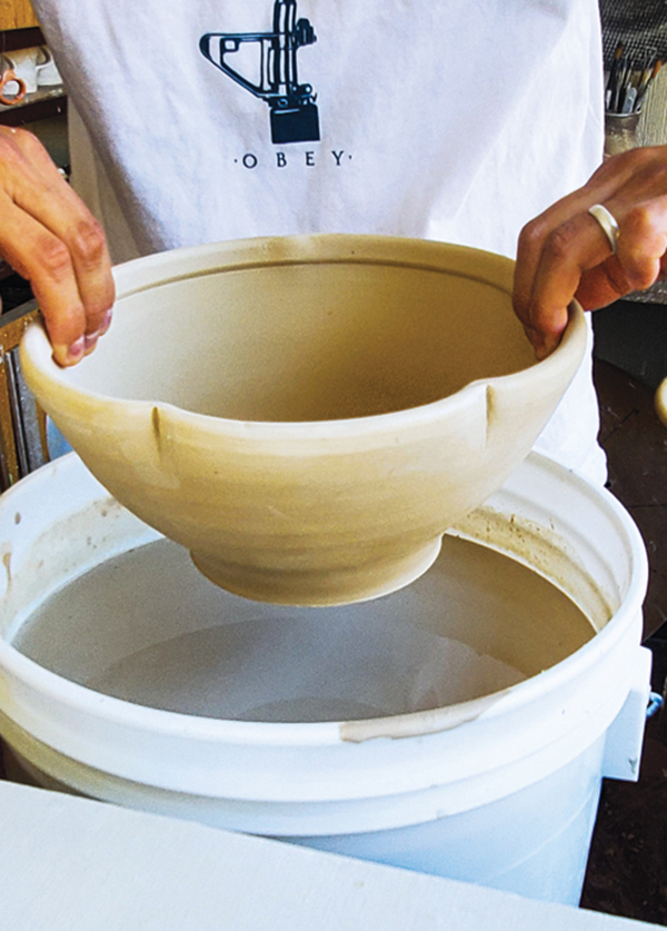 11 Dip a 5-pound bowl into flashing slip. The rim and form of the bowl allow for holding onto the pot while dipping.