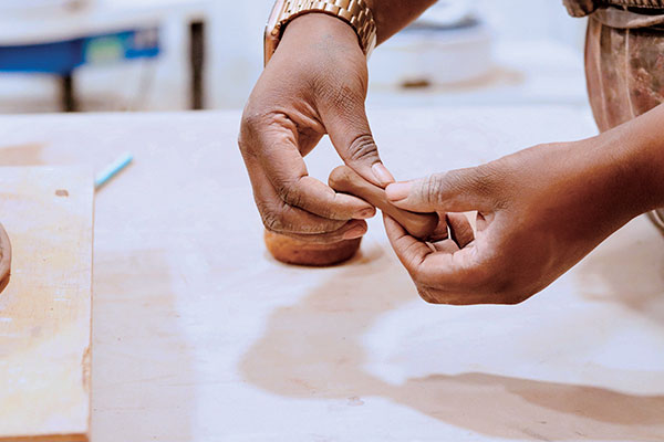 11 Create handles for the sides of the casserole and the lid by outwardly pinching three balls of clay into dog-bone shapes. 