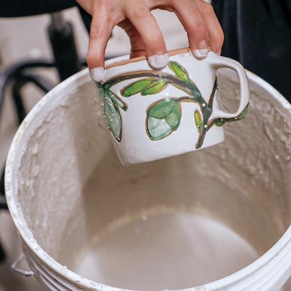 L Dip the mug into glaze. 