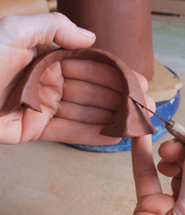 12 Remove any excess clay from each side of the handle at the connection points using angled V cuts.