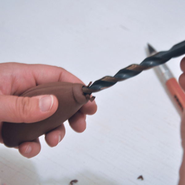 7 Create an opening in the leather-hard handle through the circular disk of clay on the end using a drill bit. 