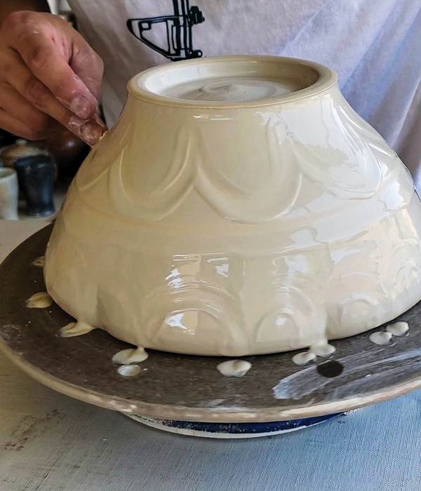 13 Make marks on the surface of the upside-down bowl while the slip is wet, with the banding wheel rotating slowly. 