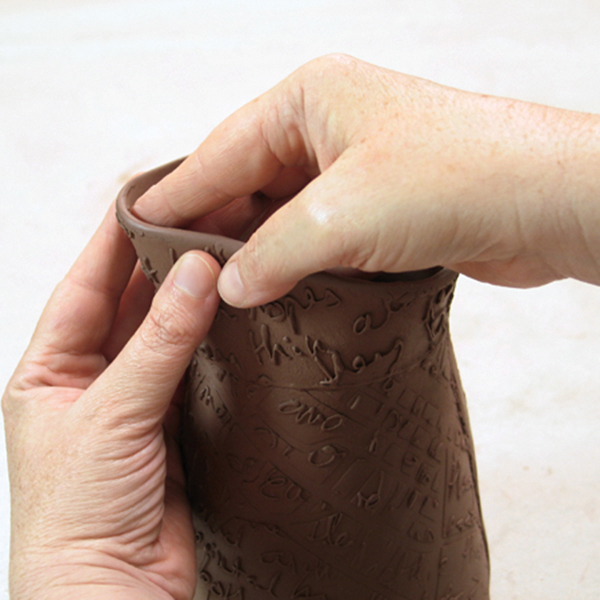 13 While the clay is still flexible, gently shape the spout of the pitcher.