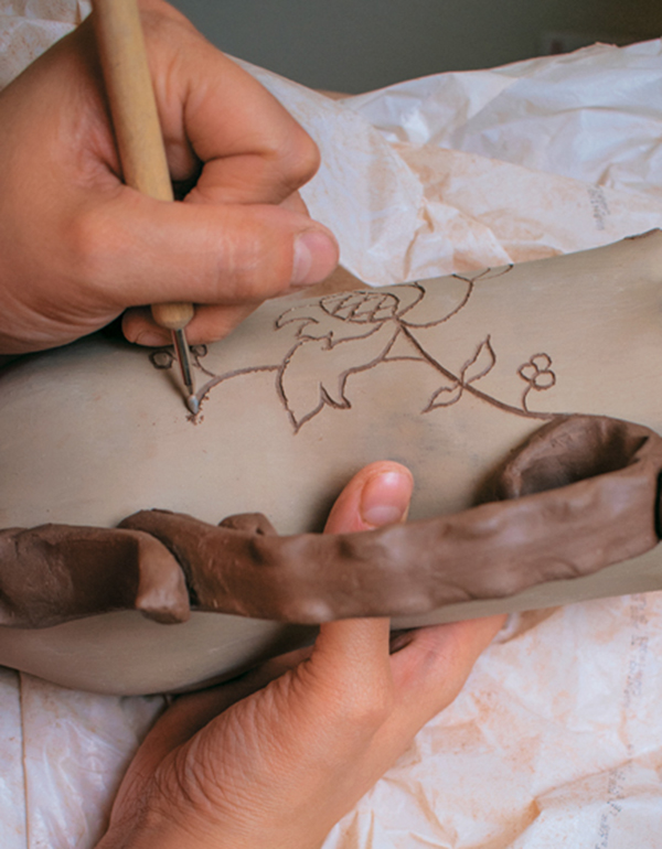 14 Carve decorations into the pot and lid using a carving stylus.