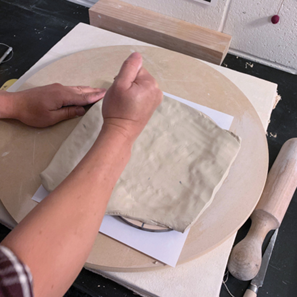 2 Place a thick clay slab over the mold and pound from the center outward. 