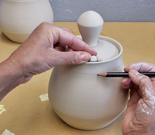 3 Attach a lid stopper on the rim of the pot so that it is in line with the handle.