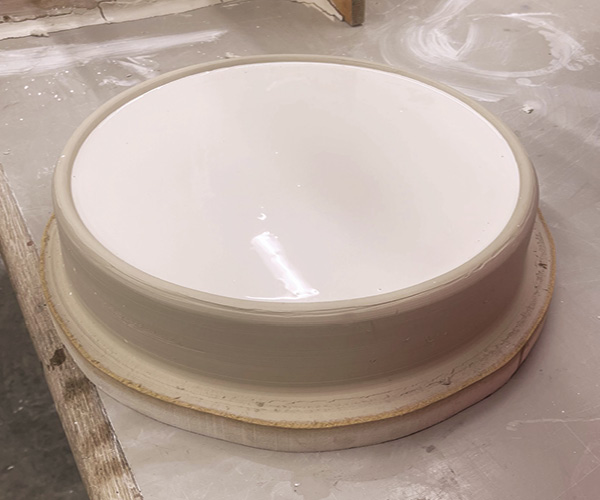 4 Move to level surface and pour plaster into the clay basin form.
