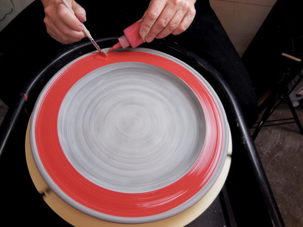 1 Center the platter on a Giffin Grip, then apply underglaze with a brush and a squeeze bottle.