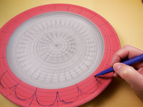 6 Mark the rim of the platter with scallops. The dividing lines and concentric circles guide placement of the shapes.