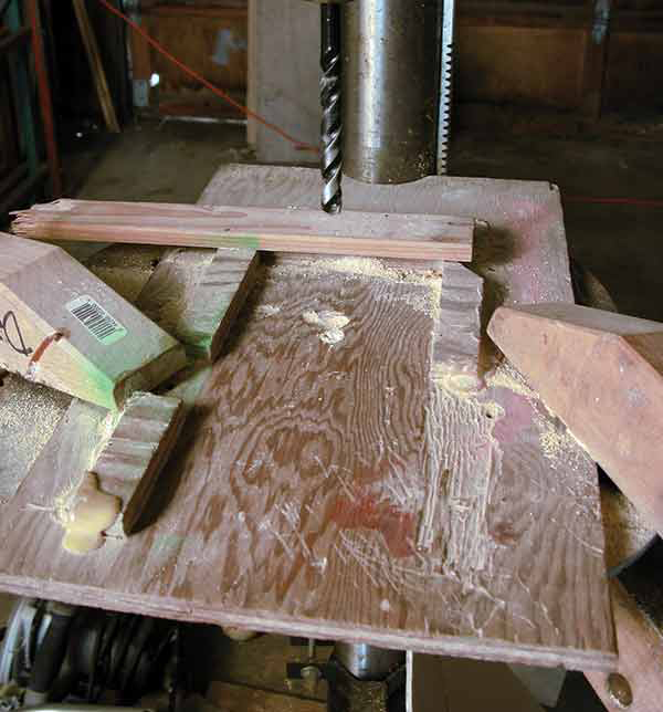 2 To ensure all the holes drilled into the bricks are in the same spot, make a jig out of scrap wood, then clamp it in place on the drill press. 