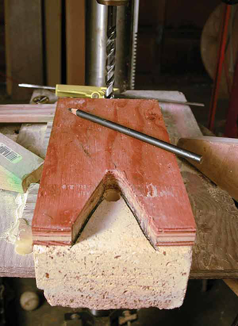 3 To avoid gaps between the bricks after adding support wires, make a wooden template that connects the bottom curve of the drilled hole to top of the brick in a V shape, with the widest part of the triangle as wide as the angle iron. Carve a groove along the line that’s wide enough for the nichrome wire