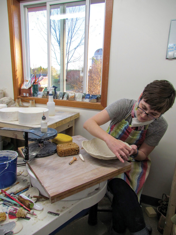 Katie Teesdale working on a pinch pot in her individual studio space.