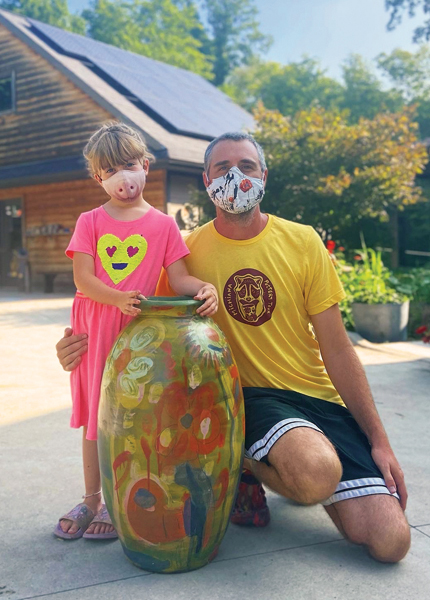 8 Bryn Rothshank and Justin Rothshank with their large flower jar, 27 in. (69 cm) in height, wheel-thrown earthenware, painted/drawn illustrations, soda fired, 2021.  