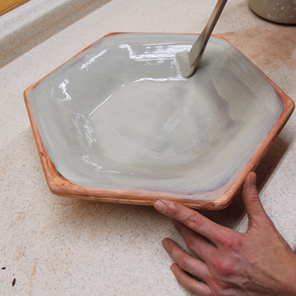 7 Add a layer of slip to the interior surface while the bowl is still in the mold. Repeat this, adding a total of three layers of slip.