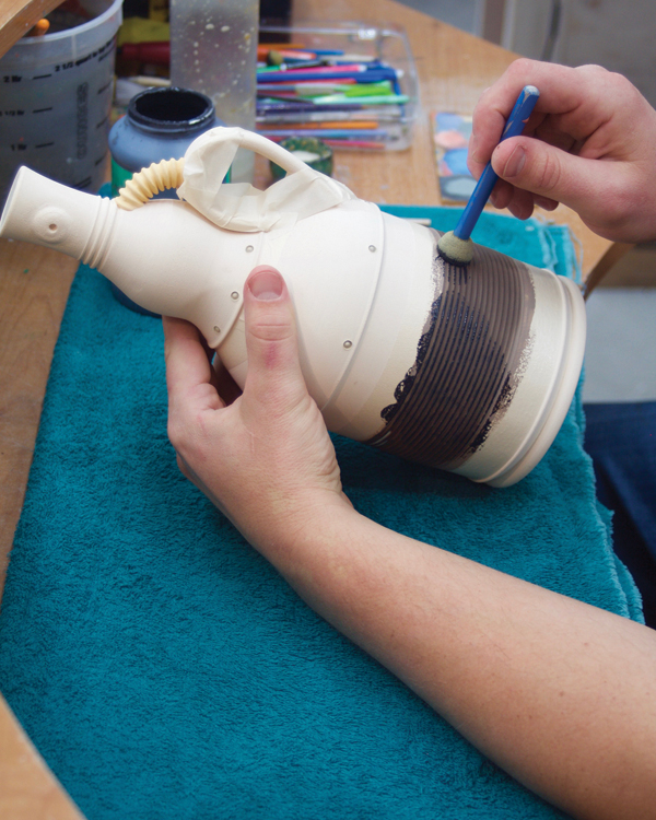 14 Mask the handle and neck. Sponge a thin layer of underglaze on the glazed center.