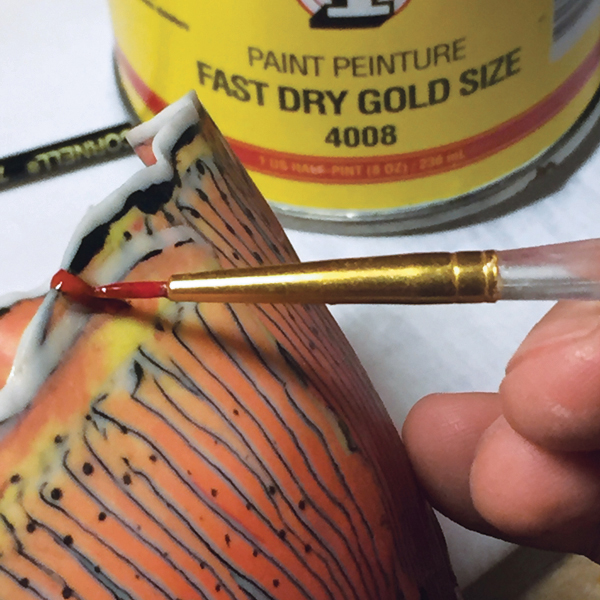 4 Brush on quick-set gold-leaf size (glue) to the epoxied area. Let dry for 30 minutes.
