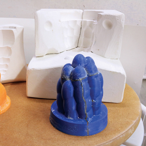 8 Plastic models shown with plaster press molds used to form the citrus reamers.