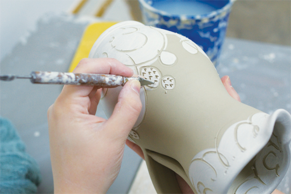 9 Carve away areas of the underglaze to create sgraffito decoration; here I’m drawing spikes on the cacti with the blade side of a clean-up tool.