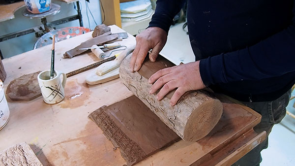 4 Ingersoll rolling a textured slab around a log to create a cylinder.