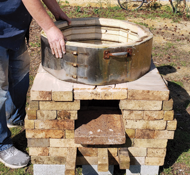 3 Stack the brick for the firebox, then place the recycled electric kiln on top.