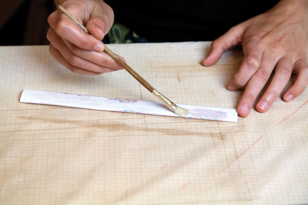 When the slip on the pattern is leather hard it is ready to transfer onto the prepared background. Press the paper smoothly onto the clay and brush enough water on the back to barely saturate the laser ink.