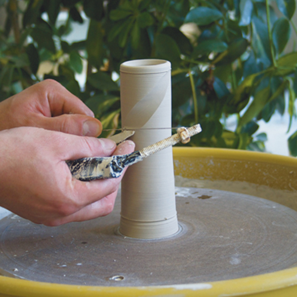 1 After horizontally marking the start and the finish lines of the pattern, begin faceting the cylinder with diagonal cuts from the top line down and then from the bottom line up.