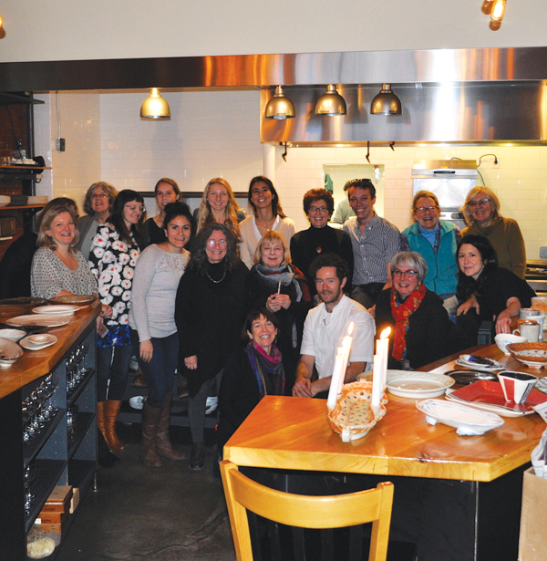7 Students in the Food for Thought class pictured with Alex Crabb of Asta (front row, third from right) and instructor Arthur Halvorsen (back row, third from right) before their end-of-semester lunch at the restaurant. Student-made plates and platters are shown on the table in the foreground.