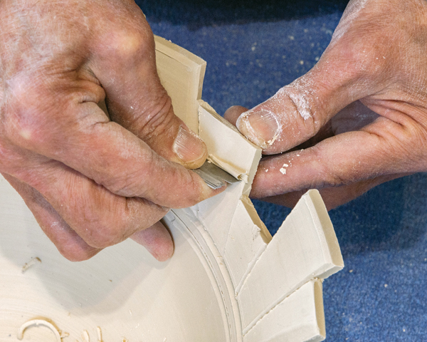 4 Support the back side or the rim edge as you shave the clay away to define the notches.